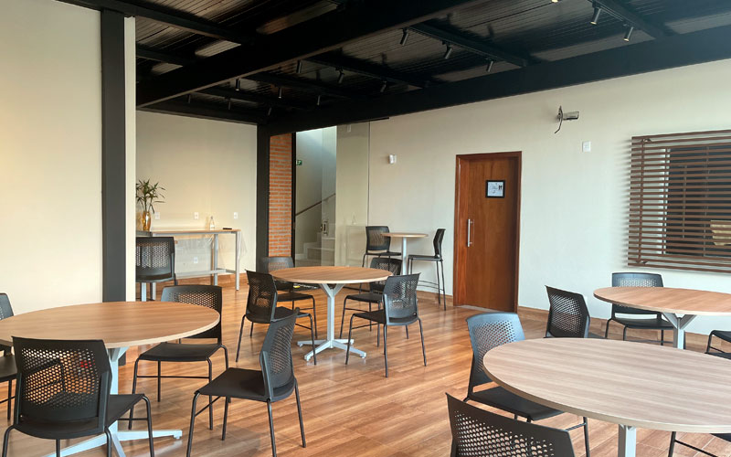 Salão de eventos em Vinhedo, São Paulo, com mesas e cadeiras organizadas para o lançamento da Missão Escandinava